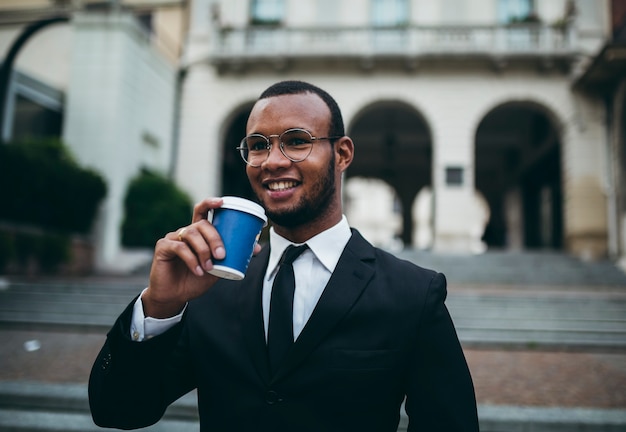 Foto empresário negro com café pela cidade