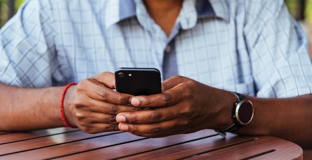 Empresario negro persona sosteniendo una pantalla en blanco de teléfono inteligente digital moderno