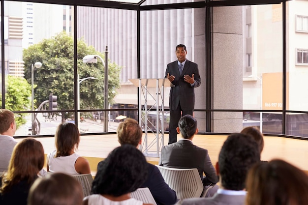 Empresario negro presentando seminario gesticulando a la audiencia