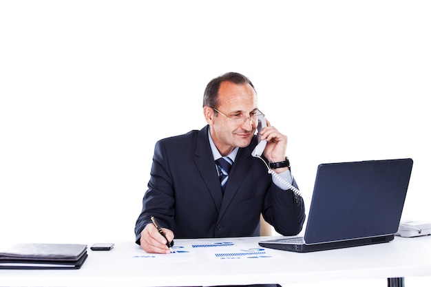 empresário no local de trabalho no escritório de um laptop falando ao telefone