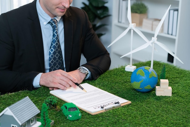 Foto empresario o director ejecutivo en el cargo firmando un acuerdo de regulación ambiental para salvar la tierra con el uso sostenible de energía y la reducción de co2 para un futuro más verde