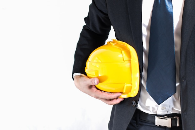 empresario o ingeniero sosteniendo el casco amarillo para la seguridad de los trabajadores