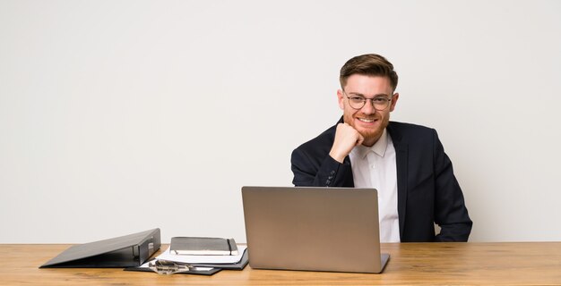 Empresario en una oficina con gafas y feliz.