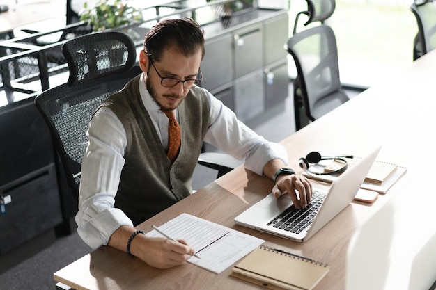 Empresario de oficina moderna que trabaja en la computadora Retrato de un exitoso ingeniero de software de TI de mediana edad que trabaja en una computadora portátil