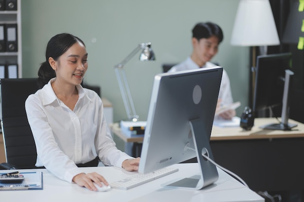 Empresario de oficina moderno trabajando en computadora Retrato de exitoso ingeniero de software de TI latino trabajando en una computadora portátil en su escritorio Lugar de trabajo diverso con profesionales Toma de vista frontal