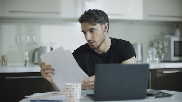 Empresário olhando papel no local de trabalho em casa Homem de negócios jovem trabalha com papéis