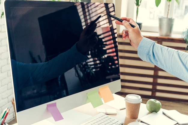 Empresário, olhando para o monitor do computador durante o dia de trabalho no escritório