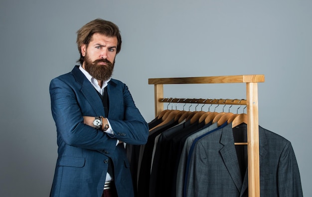 Empresário olhando sério alfaiate confiante projetando jaqueta masculina sartor bonito com fita métrica beleza masculina e moda homem barbudo costurando roupas formais e guarda-roupa de escritório