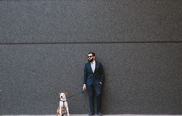 Empresario paseando a un perro en la calle