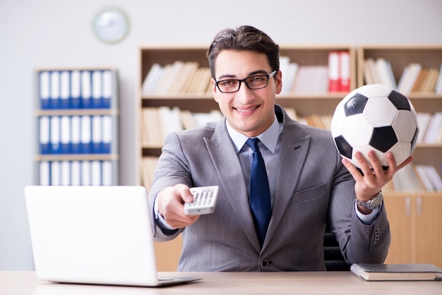 Empresario con pelota de futbol en la oficina