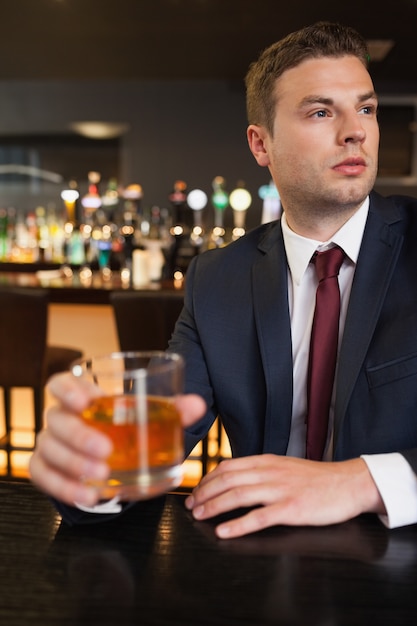 Empresario pensativo tomando una copa