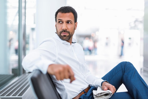 Empresario con un periódico en la sala de espera