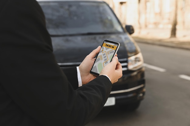 Empresario pidiendo taxi con smartphone en primer plano de la calle de la ciudad