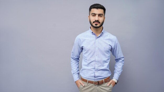Empresario de pie en camisa azul con las manos en el bolsillo modelo paquistaní indio
