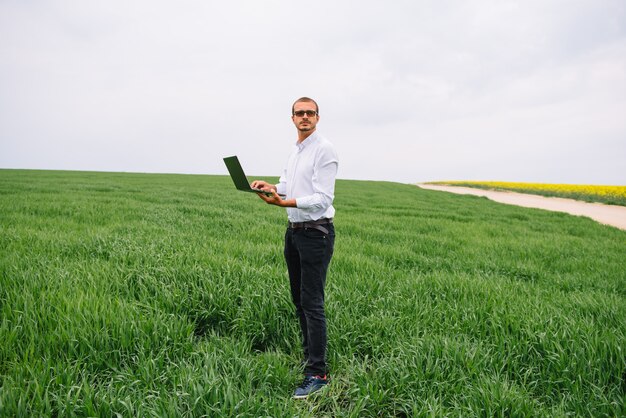 empresario de pie en un campo de trigo