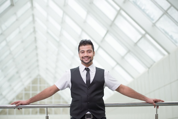 Empresario de pie en la oficina y sonrisa.