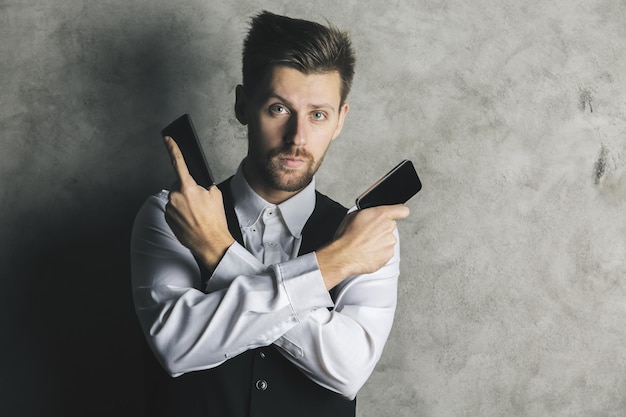 Empresario con pistolas de teléfonos inteligentes