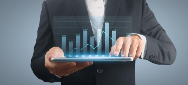 El empresario planea el crecimiento del gráfico y el aumento de los indicadores positivos en su tableta de negocios en la mano