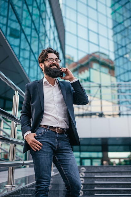 Empresario positivo respondiendo a una llamada telefónica