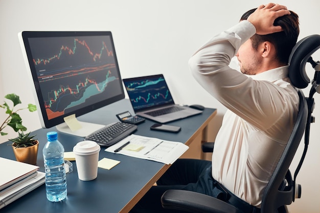 Empresario preocupado mirando los gráficos estresado por las noticias de la bolsa de valores inversor perdió dinero en línea