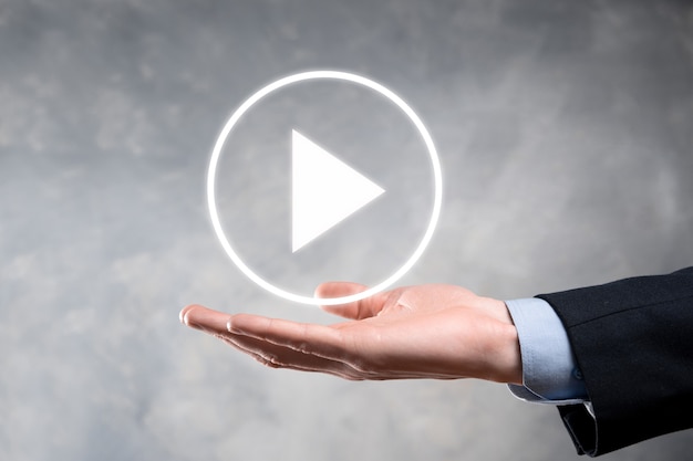 Empresario presionando, mantenga presionado el botón de reproducción para iniciar o iniciar proyectos. Presentación de reproducción de video. Idea para negocios, botón de reproductor de tecnología.media. Ícono de reproducción.Ir.