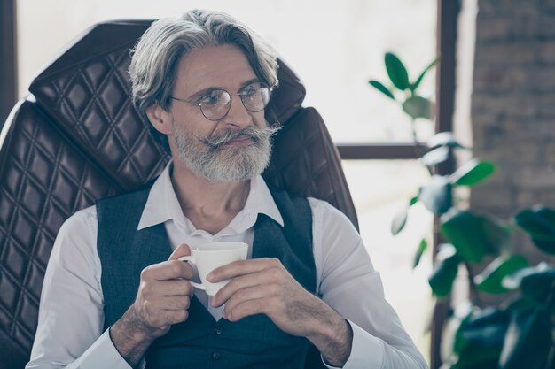 Empresario profesional sosteniendo la taza de café en la oficina industrial loft