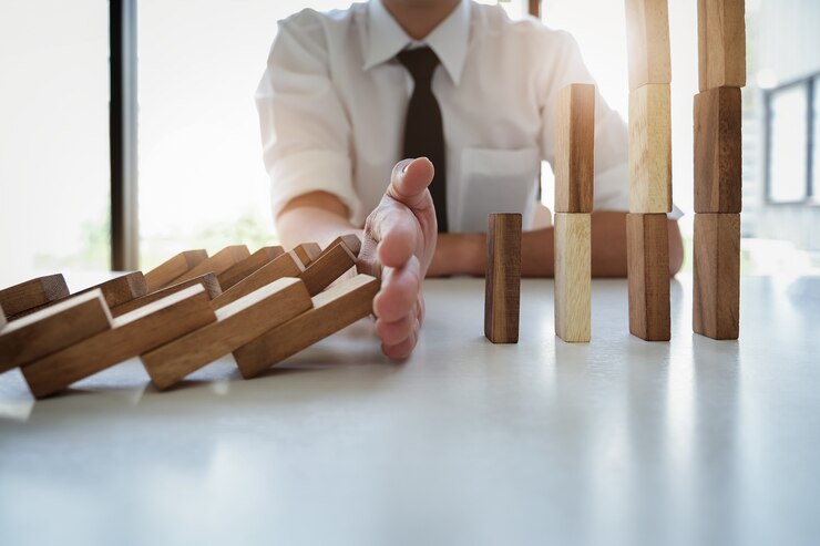 Foto empresario proteger caída de bloque de madera a la planificación y estrategia en riesgo para el negocio