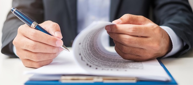 Foto empresario que firma los documentos del contrato después de leer el hombre que sostiene la pluma y aprobar el informe comercial acuerdo de contrato asociación y conceptos de trato