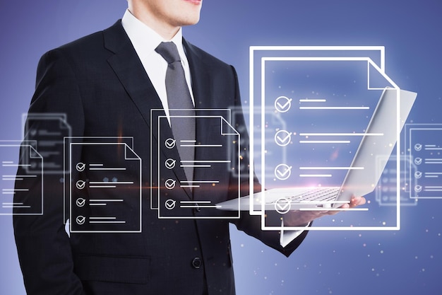 Empresario que gestiona documentos digitales con una computadora portátil y elementos gráficos