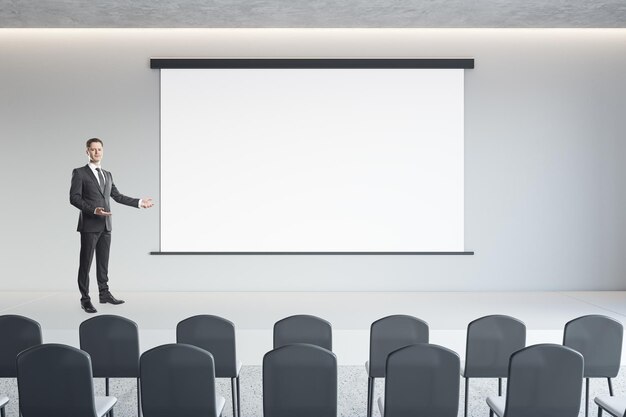 Empresario que presenta en el moderno interior del auditorio de hormigón loft