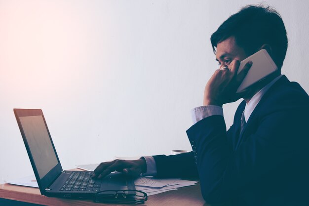 Empresario que trabaja en el teléfono sentado en un escritorio en la oficina