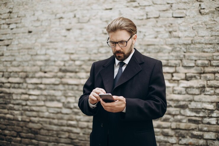 Empresario que usa el móvil para trabajar al aire libre