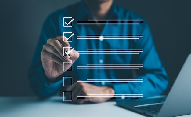Empresario que usa la pluma para marcar la marca correcta en la casilla de comprobación para la lista de control de documentos de calidad y la aprobación empresarial del concepto del proyecto Marca de comprobación Rellenando la lista de comprobación de formularios digitales Examen en línea
