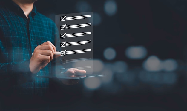 Empresario que usa una pluma para marcar la marca correcta en la lista de verificación virtual para el control de calidad y la garantía del concepto ISO