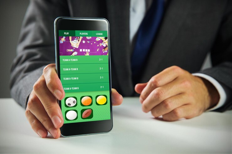 Empresario que usa un teléfono inteligente contra la pantalla de la aplicación de juego
