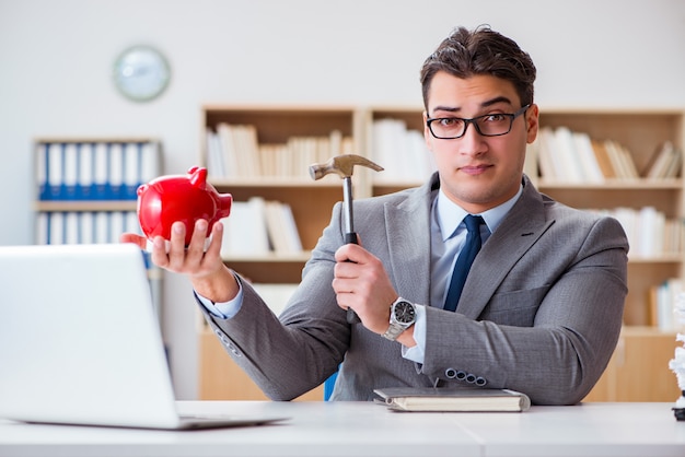 Empresário quebrando piggybank no escritório