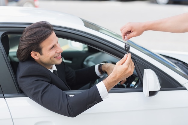 Empresario recibiendo su nueva llave de auto