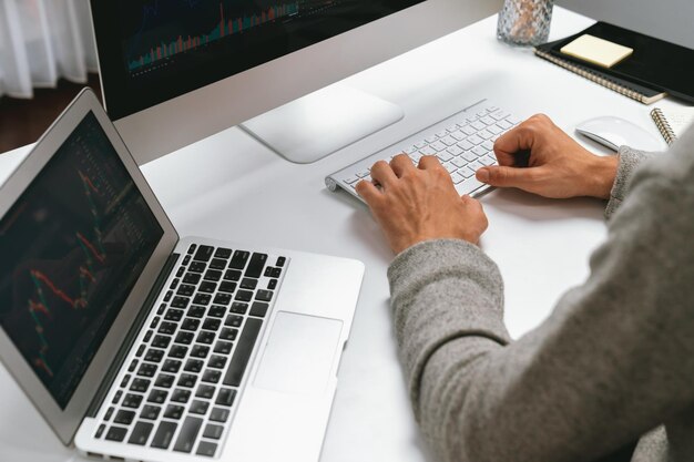 Empresario recortado usando la computadora para buscar un informe de marketing de negocios pecuniario