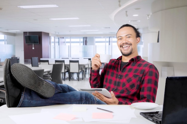 Empresário relaxando com café no escritório