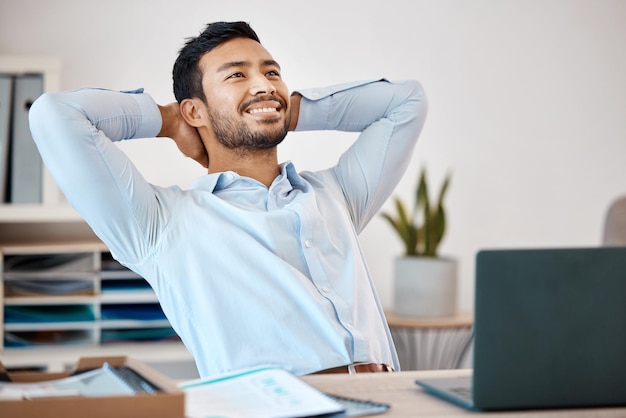 Empresário relaxando em uma mesa no escritório em seu trabalho corporativo depois de terminar um projeto Empregado feliz, calmo e sem estresse, sentado e descansando em sua mesa após um dia de trabalho bem-sucedido