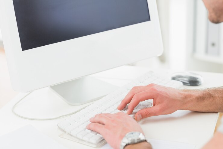 Foto empresario con reloj escribiendo en el teclado