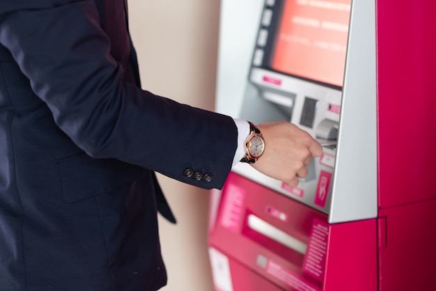 Empresario retirar dinero en efectivo en el cajero automático