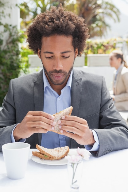 Empresario con sandwich para el almuerzo