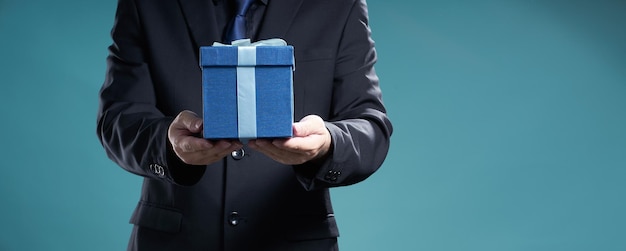 Foto empresário segura a caixa de presente para dar a alguém, feriado e conceito de presente de natal.