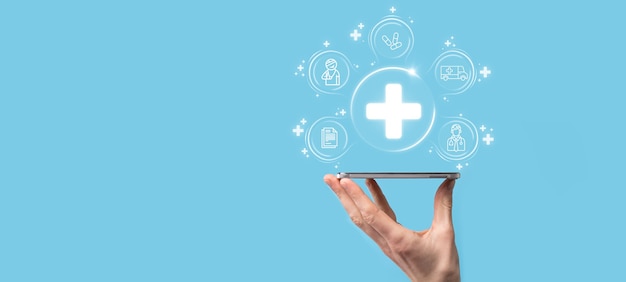 Empresário segura ícones de conexão de rede virtual e médica. A pandemia de Covid-19 desenvolve a conscientização das pessoas e espalha a atenção em seus cuidados de saúde. Médico, documento, medicina, ambulância, ícone do paciente.