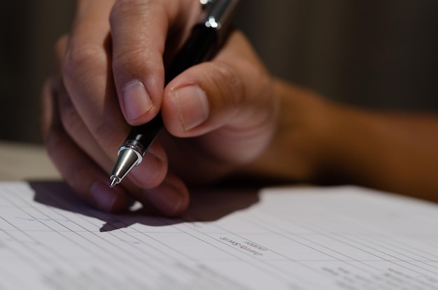 Foto empresário segurando documento de contrato de assinatura de caneta investimento financeiro ou relatório de papelada na mesa