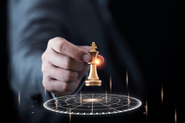 Foto empresário segurando e jogando xadrez rei dourado para o alvo virtual de dardo.