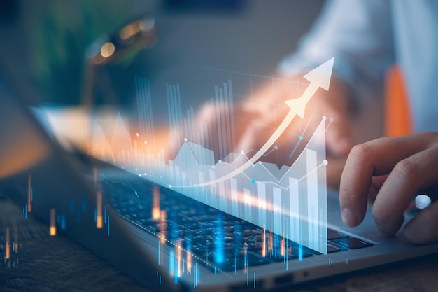 Empresário segurando moedas e um gráfico crescente ou gráfico de finanças em uma tela virtual para um negócio