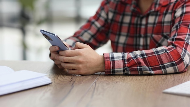 Foto empresário segurando smartphone sentado no escritório trabalhando on-line no gadget