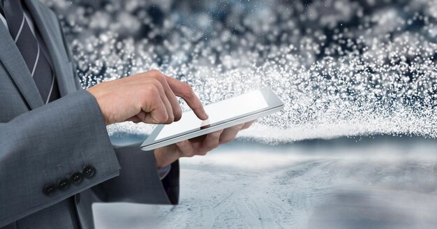 Empresário segurando tablet com neve backgorund